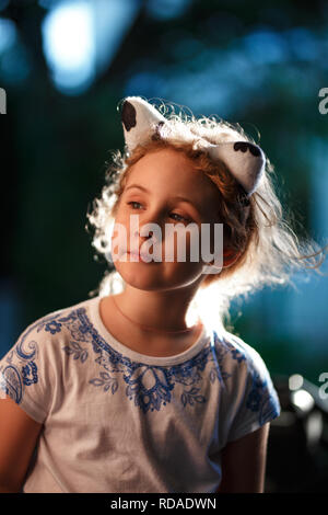 Porträt von einem hübschen blonden Mädchen draußen an einem warmen Sommerabend, die Sonne beleuchtet die Haare von hinten. Stockfoto