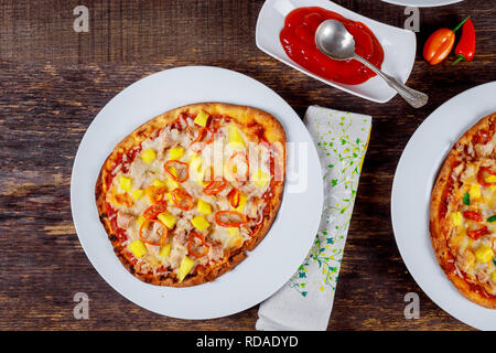 Aufnahme von oben köstliche italienische Pizza auf Holztisch mit Zutaten serviert. Stockfoto