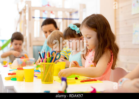 Kindergarten Kinder Kunst und Handwerk mit Lehrer in Day care center Stockfoto