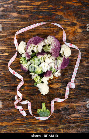 Ein Blumenkohl und Brokkoli mit einem Blumenstrauß auf einer hölzernen Hintergrund gefüttert Stockfoto