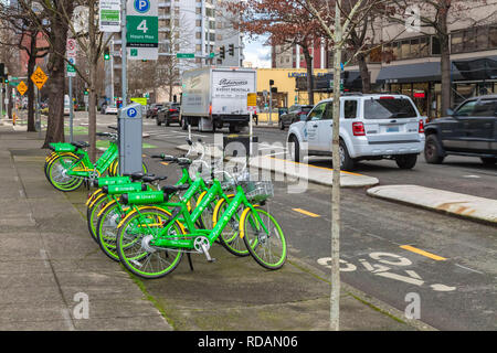 Leihfahrräder Line Up auf dem Gehweg entlang der Straße in der Innenstadt von Seattle, Washington, United States. Stockfoto