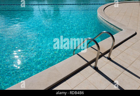Metall Geländer der Pool mit Treppe mit frischem Wasser im Sonnenlicht Stockfoto