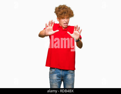 Junger stattlicher Mann mit afro Haar zu tragen rote T-Shirts mit Angst und Furcht Ausdruck stop Geste mit den Händen, Angst, Schreien im Schlag. Panik conc Stockfoto