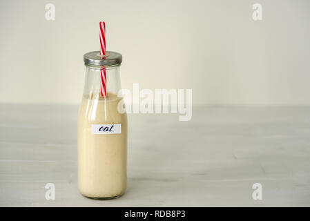 Glas Flasche Hafermilch auf weißem Hintergrund. Stockfoto