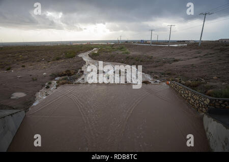 Abfluss von Wasser aus einem Monsun Gewitter fließt eine channelized Arroyo in der Nähe von einem neuen Wohngebiet Unterteilung Immobilien Stockfoto