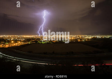 Blitzeinschläge zentrale El Paso, Texas, in einer Sommernacht, wie der Verkehr auf der Straße hinterlässt leichte Wanderwege Stockfoto