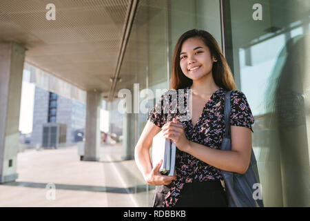 Junge asiatische Student selbstbewusst lächelnd beim Stehen auf dem Campus Stockfoto