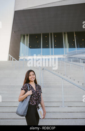 Lächelnden jungen asiatischen Studenten stehen durch Campus Treppe Stockfoto