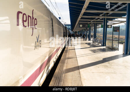 Hochgeschwindigkeitszug Ave auf der Plattform des Camp de Tarragona Bahnhof und Reisende mit Koffern Verlassen der Station geparkt. Tarragona, Spanien Stockfoto