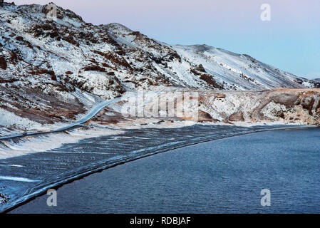 Kleifarvatn See Islands an einem Wintertag mit einer malerischen Straße im Schnee Stockfoto