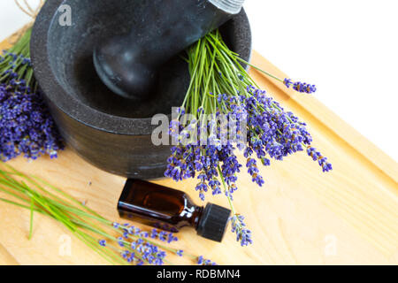 Heilkräuter, schwarz Mörser mit Lavendelblüten, Flasche mit Öl, Kräutermedizin Stockfoto
