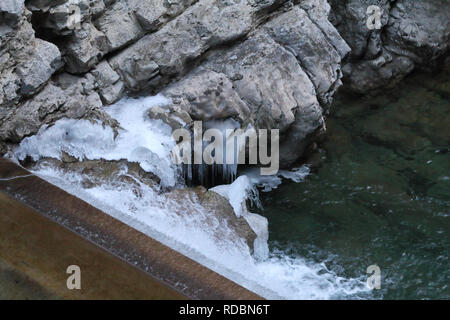 Ein kleiner Wasserfall auf Beton in der sirop Fluss mit grauem Rock und kaltem Eis Stalaktiten in den Foz de Binies Zone, im Winter, in Aragon, Spanien Stockfoto