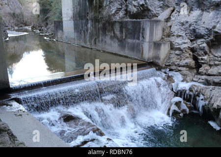 Ein kleiner Wasserfall auf Beton in der sirop Fluss mit grauem Rock und kaltem Eis Stalaktiten in den Foz de Binies Zone, im Winter, in Aragon, Spanien Stockfoto