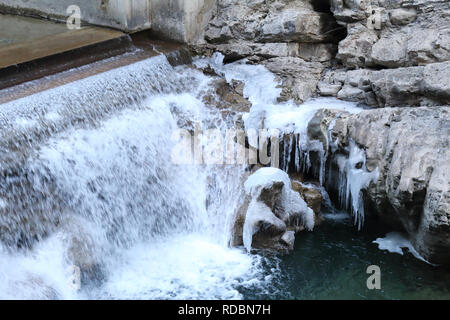 Ein kleiner Wasserfall auf Beton in der sirop Fluss mit grauem Rock und kaltem Eis Stalaktiten in den Foz de Binies Zone, im Winter, in Aragon, Spanien Stockfoto