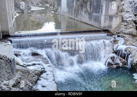 Ein kleiner Wasserfall auf Beton in der sirop Fluss mit grauem Rock und kaltem Eis Stalaktiten in den Foz de Binies Zone, im Winter, in Aragon, Spanien Stockfoto