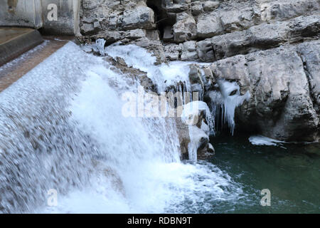 Ein kleiner Wasserfall auf Beton in der sirop Fluss mit grauem Rock und kaltem Eis Stalaktiten in den Foz de Binies Zone, im Winter, in Aragon, Spanien Stockfoto