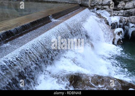 Ein kleiner Wasserfall auf Beton in der sirop Fluss mit grauem Rock und kaltem Eis Stalaktiten in den Foz de Binies Zone, im Winter, in Aragon, Spanien Stockfoto