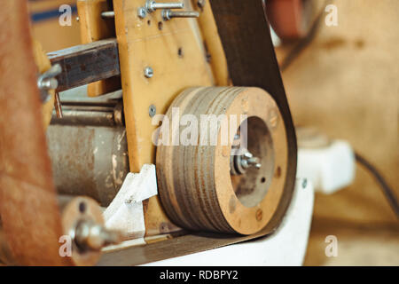 Alte Schleifmaschine und Rad in der Werkstatt oder kleine Fabrik blur Hintergrund Stockfoto