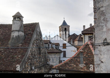 Traditionelle Häuser mit runde Schornsteine in einem Pyrenäen Dorf mit Häusern aus Stein und dunklen Dächern im Winter in Hecho, Region Aragon, Spanien Stockfoto