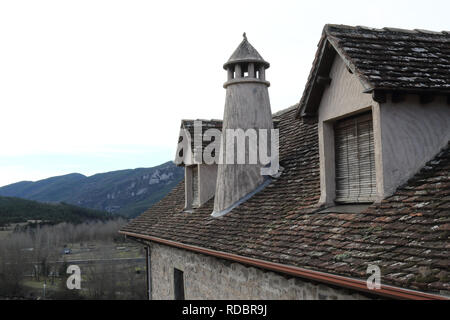 Ein traditionelles Haus dunklen Dach mit zwei Mansarde Windows, runde Schornstein in einem Pyrenäen Dorf im Winter in Hecho, Region Aragon, Spanien Stockfoto