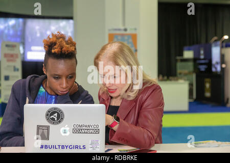 Detroit, Michigan - Zwei Frauen arbeiten auf einem Laptop während der North American International Auto Show. Stockfoto