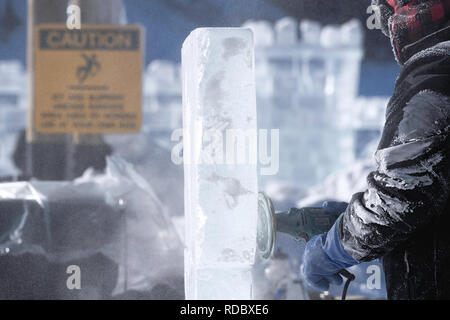 Eis Bildhauer mit einem elektrischen Schleifer ein Blatt des Eises am Lake Louise Ice Magic Festival im Banff National Park, Alberta Kanada zu polnischen Stockfoto