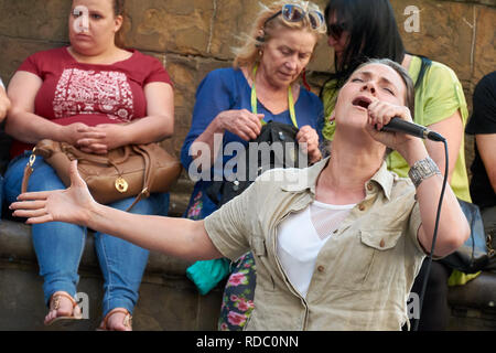 Straßenmusikanten, die eine spektakuläre Show auf der Piazza della Signoria vor einer Masse in Florenz, Italien. Stockfoto