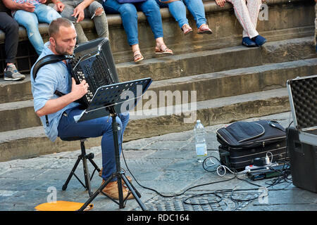 Straßenmusikanten, die eine spektakuläre Show auf der Piazza della Signoria vor einer Masse in Florenz, Italien. Stockfoto