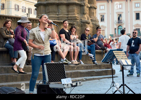 Straßenmusikanten, die eine spektakuläre Show auf der Piazza della Signoria vor einer Masse in Florenz, Italien. Stockfoto