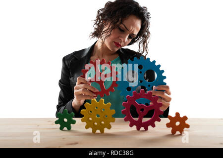 Geschäftsfrau versucht Gänge Stücke zu verbinden. Konzept der Teamarbeit, Partnerschaft und Integration Stockfoto