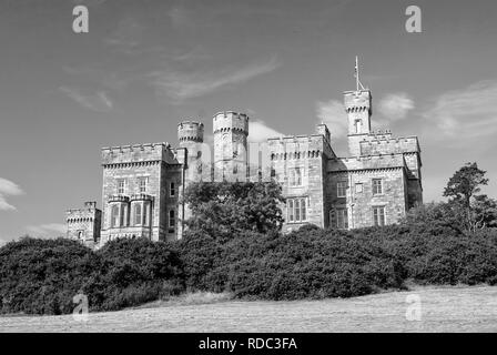 Lews Castle auf blauen Himmel in Stornoway, Vereinigtes Königreich. Schloss mit grünen Bäumen auf natürliche Landschaft. Hotel im viktorianischen Stil, Architektur und Design. Sehenswürdigkeiten und Attraktionen. Sommer Urlaub und Fernweh. Stockfoto