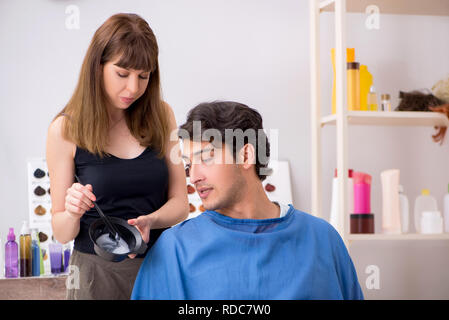 Junge attracrive Mann Besuch weiblicher Friseur Stockfoto