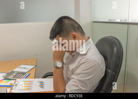 Asiatische manager erschöpft und frustriert nach der Prüfung viele Verkaufsberichte Stockfoto