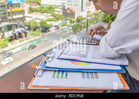 Junge asiatischer Mann tun, monatliche Finanzberichte Stockfoto