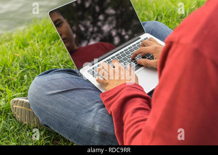 Mann mit Laptop Outdoor im Park Stockfoto
