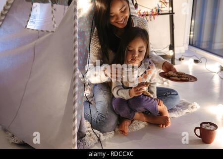 Foto von Amazing Asian Familie Mutter und Tochter essen Cookies beim zusammen in Ruhe zu Hause spielen Kinder Zelt Stockfoto