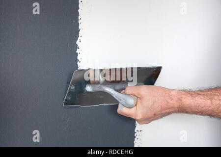 Hand mit einer Kelle Verputzen der Wand mit dekorativen Putz Stockfoto