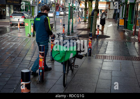 Junge Postbote mit Fahrrad auf der Straße, Killarney, County Kerry, Irland. Berufe Konzept. Stockfoto