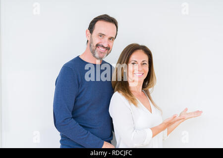 Schönen mittleren Alter Paar in Liebe über isolierte Hintergrund Einladenden natürlichen lächelnd mit offenen Hand eingeben Stockfoto