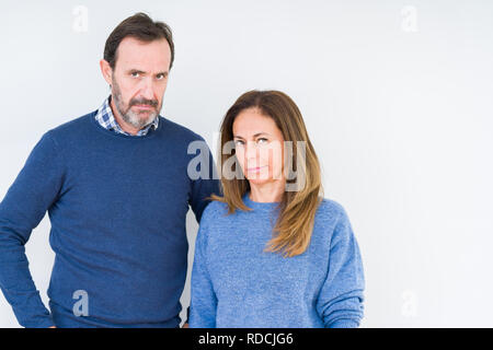 Schönen mittleren Alter Paar in Liebe über isolierte Hintergrund Skeptiker und nervös und runzelte verärgert wegen des Problems. Negative Person. Stockfoto