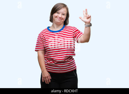 Junge erwachsene Frau mit Down-syndrom über isolierte Hintergrund angezeigt und zeigen mit den Fingern Nummer drei, während lächelte zuversichtlich und fröhlich. Stockfoto