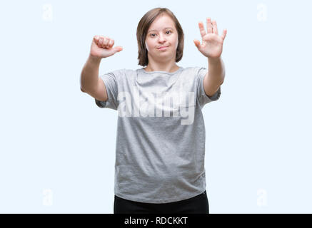 Junge erwachsene Frau mit Down-syndrom über isolierte Hintergrund angezeigt und zeigen mit den Fingern Nummer sechs, während lächelte zuversichtlich und fröhlich. Stockfoto