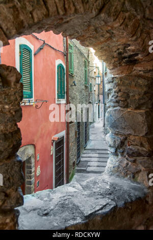 Blick auf eine schmale Straße durch einen alten Stein Fenster in Tellaro, La Spezia, Ligurien, Italien Stockfoto