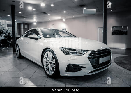 Komfortable weißes Auto scheint beim Stehen in der Autohaus Stockfoto