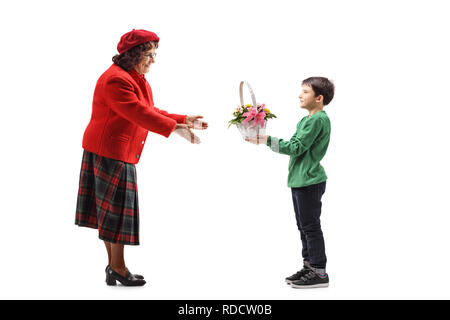 Volle Länge Schoß eines Jungen geben einen Korb mit Blumen zu seiner Großmutter isoliert auf weißem Hintergrund Stockfoto