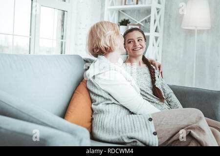 Frohe glückliche Mädchen und ihre Großmutter auf dem Sofa sitzt. Stockfoto