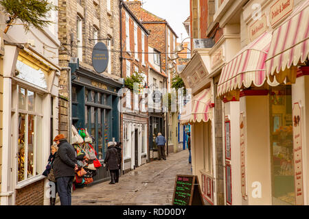 Whitby Stadtzentrum, kalte Winter Tag und Menschen Window Shopping in einer der Städte Gassen, Whitby, North Yorkshire, England, Großbritannien Stockfoto