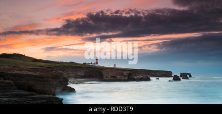 Dramatische Wolken Rückzug als Sonnenuntergang leuchtet der Himmel über Souter Leuchtturm, während das Meer stürzt gegen die Klippen an der nordöstlichen Küste Stockfoto