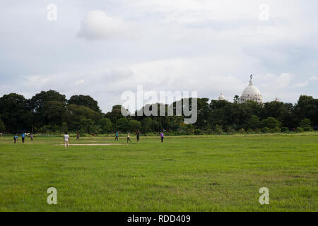 Kolkata, Bengalen/Indien - 08. August 2015: Jungen Kricket spielen auf dem Maidan in Kalkutta. Im Hintergrund das Victoria Memorial. Stockfoto