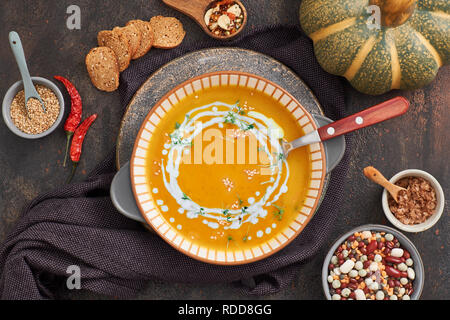 Kürbis, Bohnen und Süßkartoffeln creme Suppe in Keramik Schüssel, Ansicht von oben mit Zutaten und Gewürze Stockfoto